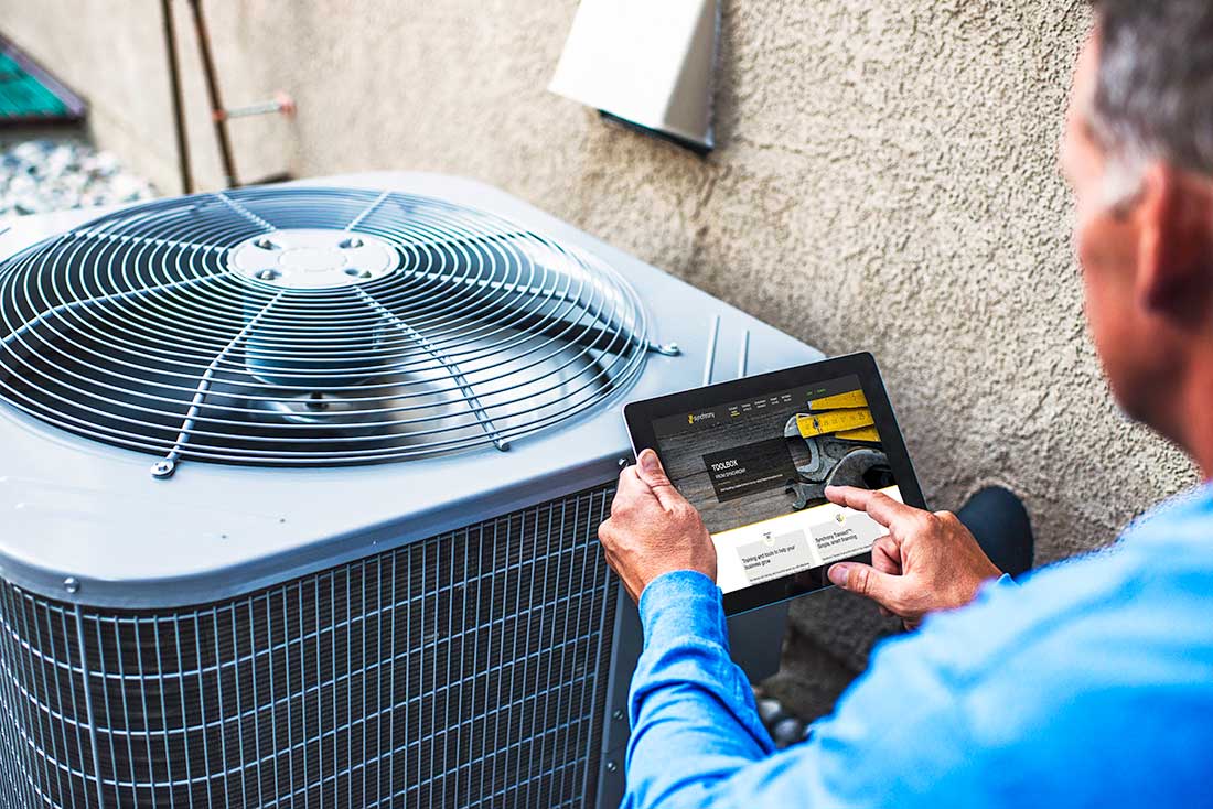 HVAC professional with tablet accessing Synchrony business tools.