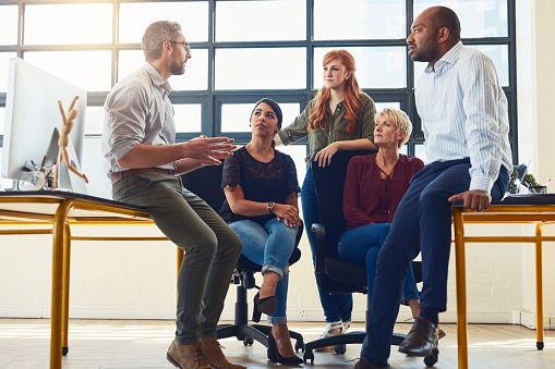 Group of business men and women in a collaborative conversation